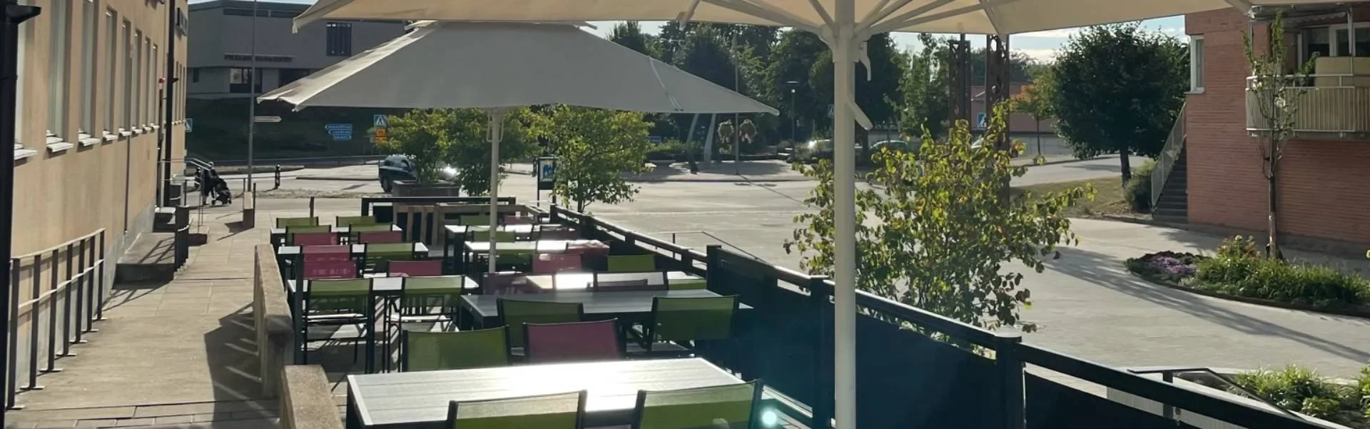 HUGO Finspångs uteservering med bord och parasoller
